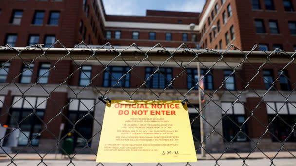 PHOTO: A yellow 'official notice do not enter' sign hangs on a fence around The Davenport, 324 Main Street, in Davenport, Iowa, on May 29, 2023, after a section of the building collapsed. (Nikos Frazier/Quad City Times via AP)