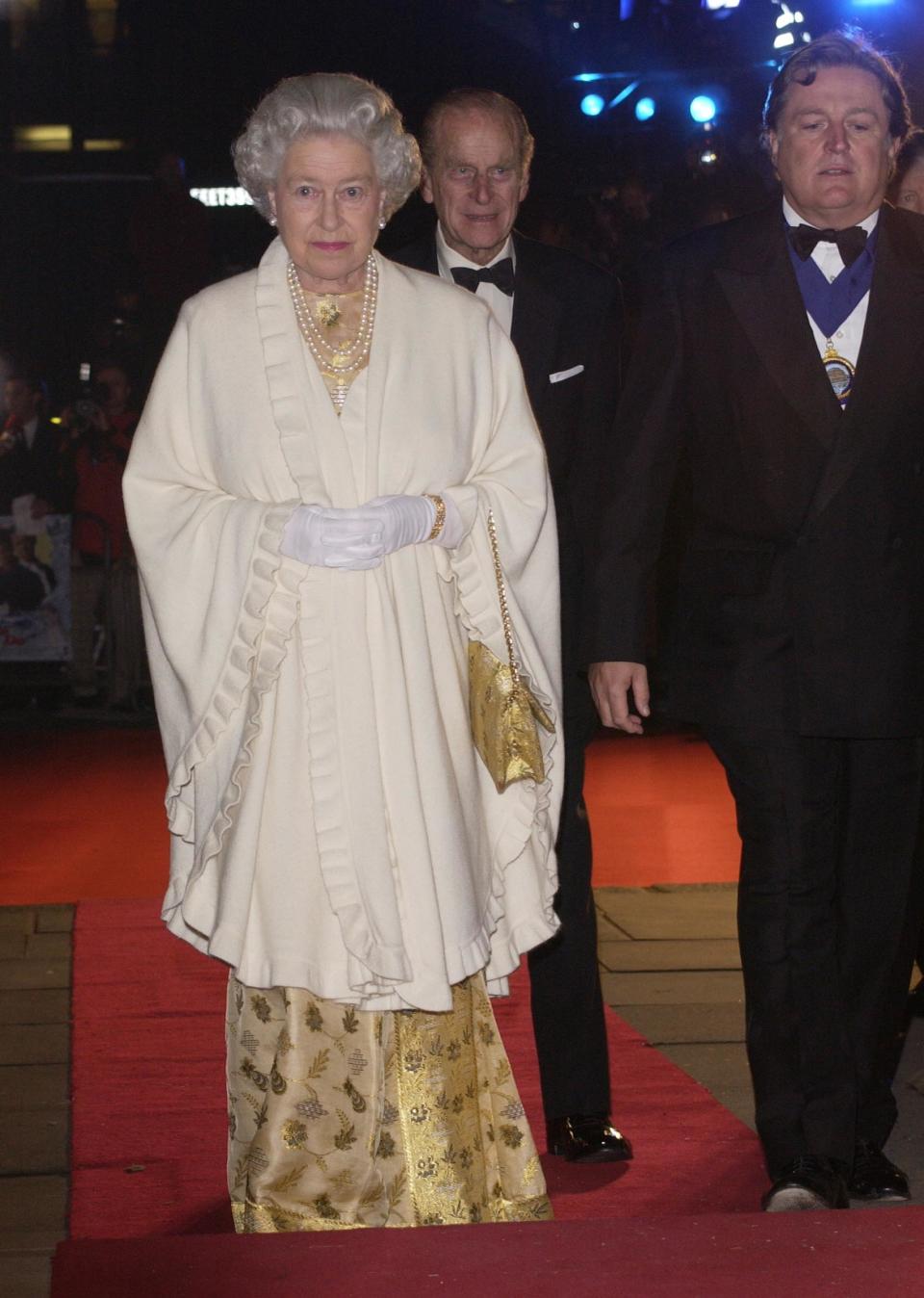<p>Only the Queen can rock metallics, as the royal took to the red carpet back in 2002 wearing head-to-toe gold. (Getty Images)</p> 