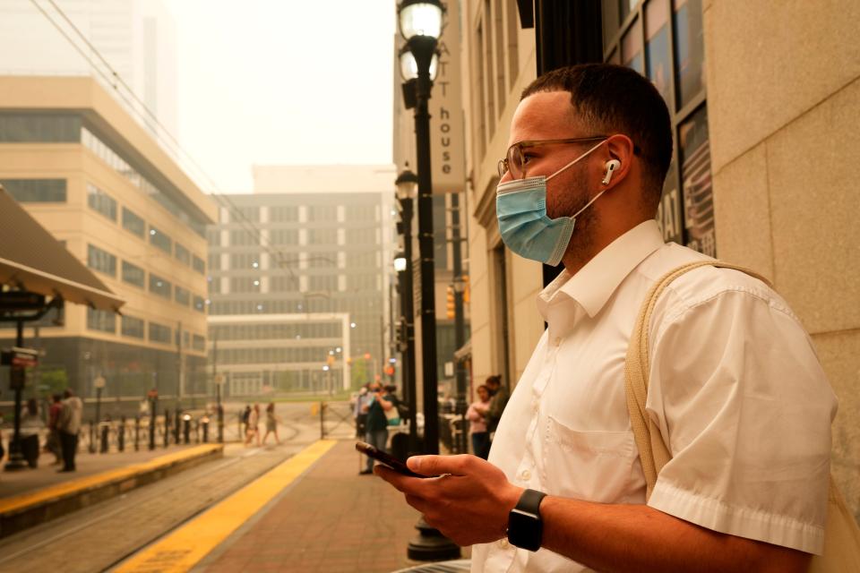 A man wears mask to protect himself from the smoke as he waits for the light rail train in Jersey City. Wednesday, June 7, 2023