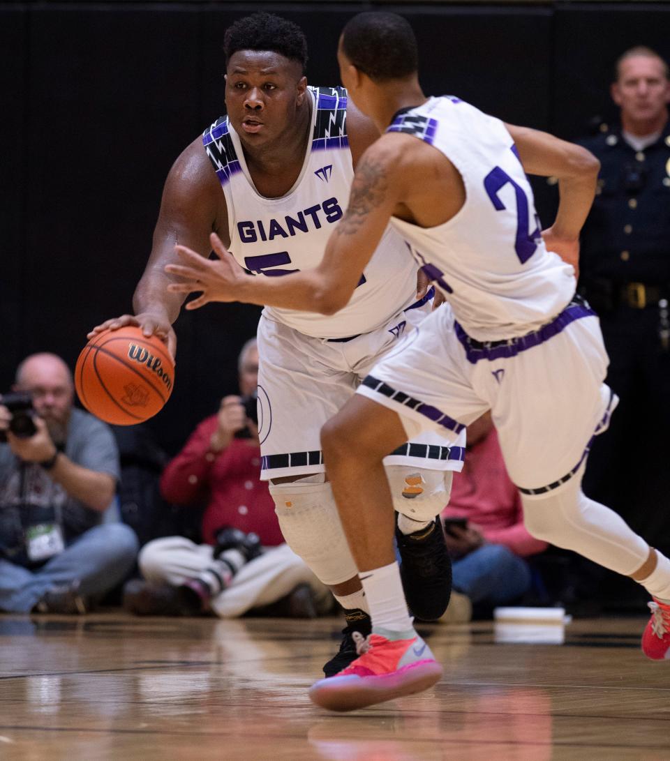 Ben Davis's Dawand Jones (54) brings the ball up court after grabbing a rebound against Center Grove during the Indiana 4A boys basketball state semifinal on March 17, 2019, in Washington, Ind.