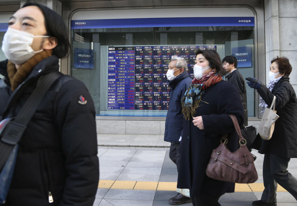 People walk by an electronic stock board of a securities firm in Tokyo, Friday, Feb. 7, 2014. Asian stock markets were mostly higher Friday, mirroring gains on Wall Street in anticipation of a positive U.S. jobs report for January. Japan's benchmark Nikkei 225 index surged 1.6 percent to 14,382.77. (AP Photo/Koji Sasahara)