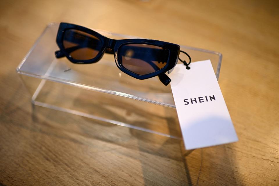 A pair of black sunglasses propped on a table with a Shein tag.