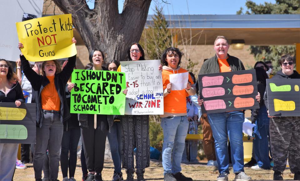 Students at East High School in Pueblo, Colo., hold signs with messages protesting gun violence during a walkout event at the high school on Wednesday.