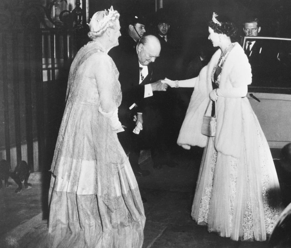 Prime minister Winston Churchill kisses Queen Elizabeth II’s hand as she leaves No 10 after a dinner given by the PM on 4 April 1955. Churchill was the first PM the Queen worked with during her reign (AFP/Getty)