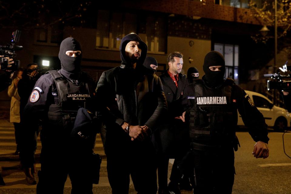 Andrew Tate and Tristan Tate are escorted by police officers outside the headquarters of the Directorate for Investigating Organized Crime (REUTERS)