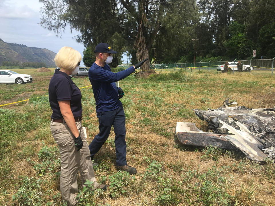 FILE - In this Sunday, June 23, 2019 file photo released by the National Transportation Safety Board, NTSB investigator Elliott Simpson, right, briefs NTSB Board Member Jennifer Homendy at the scene of a skydiving plane crash at Dillingham Airfield in Waialua, Hawaii. Federal officials released documents Wednesday, Oct. 28, 2020 that provide details about the 2019 crash that killed 11 people in Hawaii. The public docket contains reports from a National Transportation and Aviation Administration investigation into the crash. (National Transportation Safety Board via AP, File)