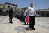 Muslims stand in line before taking part in Friday prayers at al Husseini mosque in Amman