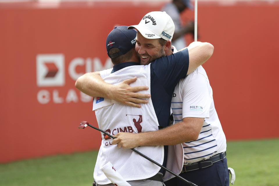 Marc Leishman of Australia celebrates with his caddie after winning the CIMB Classic golf tournament at Tournament Players Club (TPC) in Kuala Lumpur, Malaysia, Sunday, Oct. 14, 2018. (AP Photo/Vincent Phoon)