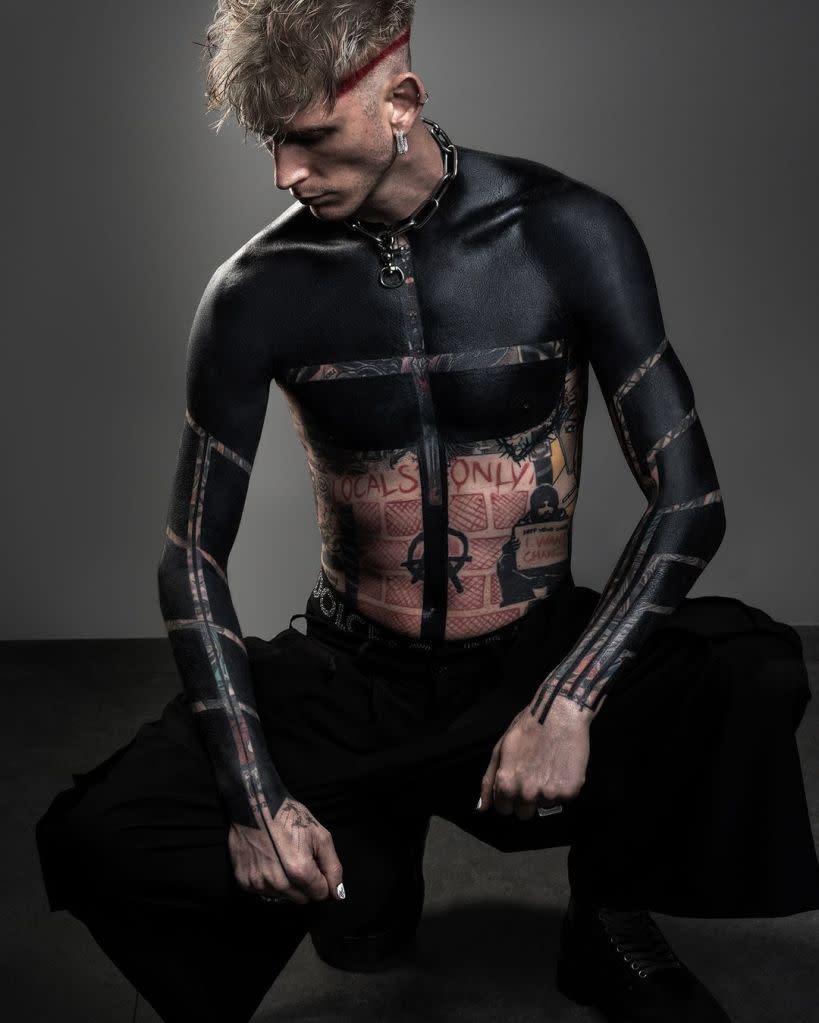 Machine Gun Kelly shows off new black-out tattoos covering his arms and torso. ROXX/Instagram