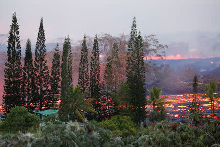 Lava flows near a house on the outskirts of Pahoa during ongoing eruptions of the Kilauea Volcano in Hawaii, U.S., May 19, 2018. REUTERS/Terray Sylvester