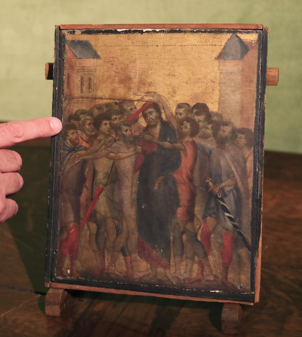 Art expert Stephane Pinta points to a 13th century painting by Italian master Cimabue in Paris, Tuesday, Sept. 24, 2019. A rare 13th century painting by Italian master Cimabue has been found in a French kitchen, and is now expected to fetch millions of euros at an upcoming auction. (AP Photo/Michel Euler)