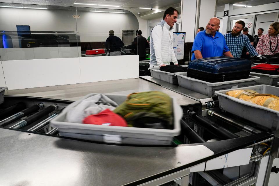 People wait for their belongings at the Transportation Security Administration security area at the Hartsfield-Jackson Atlanta International Airport on Wednesday, Jan. 25, 2023, in Atlanta.