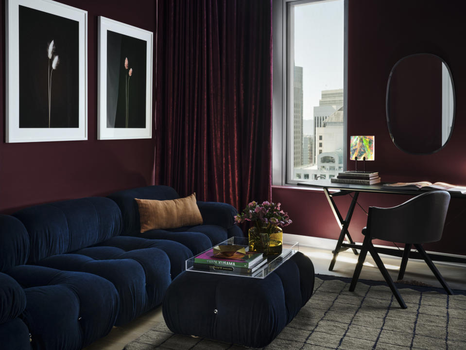 This image provided by frenchCalifornia shows a living room. A San Francisco home done by interiors firm frenchCalifornia, features this stylish space painted in Backdrop's Lobby Scene, a dark, warm purple-red that was inspired by Wes Anderson's The Grand Budapest Hotel and the color of the lobby boy's uniform. (frenchCalifornia/Douglas Friedman via AP)