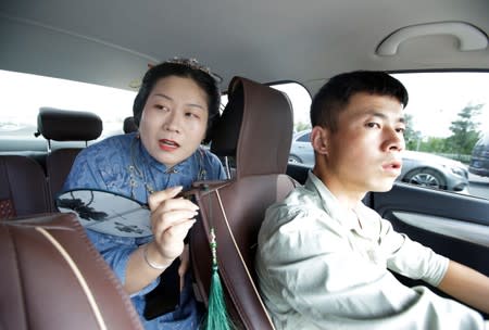 Li Doudou, dressed in "Hanfu" speaks to a taxi driver on her way to attend a performance of the "guqin" traditional musical instrument in Beijing, China