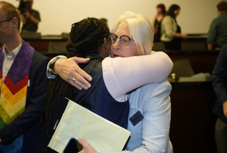 Nadine Bridges, left, executive director of One Colorado, hugs Mardi Moore after a news conference Friday, June 30, 2023, in Denver, about the U.S. Supreme Court ruling that allows a Colorado Christian graphic artist who wants to design wedding websites to refuse to work with same sex couples. (AP Photo/David Zalubowski)