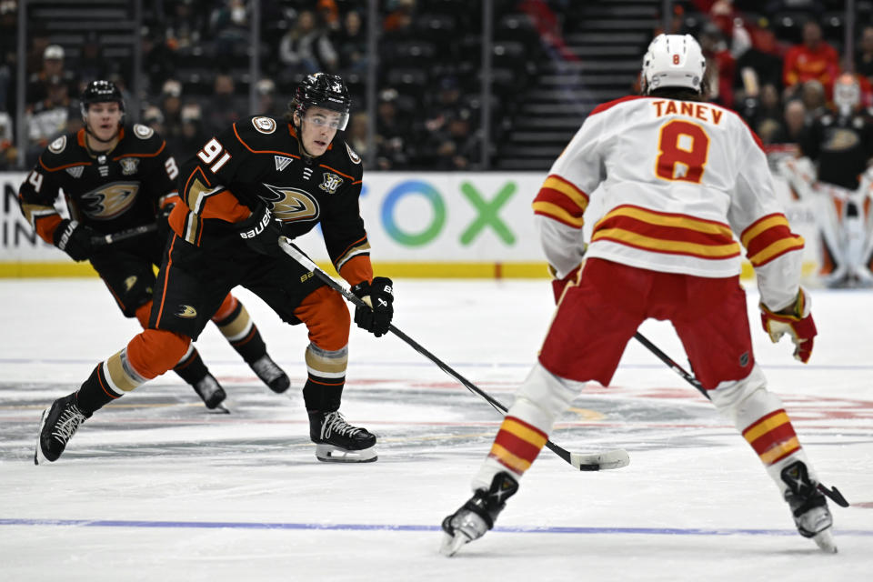 Anaheim Ducks center Leo Carlsson (91) controls the puck against Calgary Flames defenseman Chris Tanev (8) during the first period of an NHL hockey game in Anaheim, Calif., Thursday, Dec. 21, 2023. (AP Photo/Alex Gallardo)