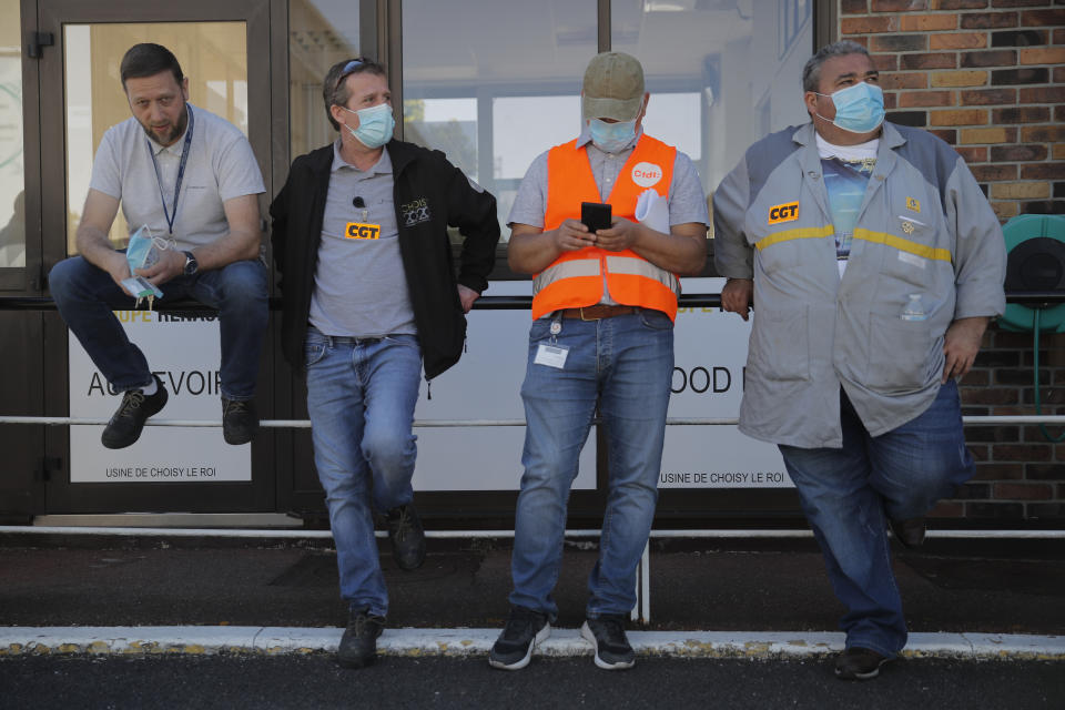 Protesting Renault workers stand outside their plant Friday, May 29, 2020 in Choisy-le-Roi, outside Paris. Struggling French carmaker Renault announced 15,000 job cuts worldwide as part of a 2 billion euros cost-cutting plan over three years. The cost-cutting plan comes as Renault came into the virus crisis in particularly bad shape. Its alliance with Nissan and Mitsubishi is a major global auto player but has struggled since the 2018 arrest of its longtime star CEO Carlos Ghosn. (AP Photo/Christophe Ena)