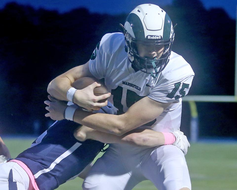 Marshfield's Tor Maas is brought down by Plymouth North's Matt Tull during first quarter action of their game at Plymouth North High School on Friday, Oct. 20, 2023. Marshfield would go on to win 49-28.