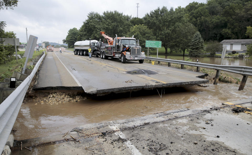 FILE - This Aug. 21, 2018, file photo, shows a milk truck damaged after it fell into the missing section of a bridge over Highway 14 in Black Earth, Wis. More than 11 inches of rain fell overnight in places in or around Madison, according to the National Weather Service. Officials in Dane County say this week's flooding caused more than $100 million in damage. (Steve Apps/Wisconsin State Journal via AP, File)