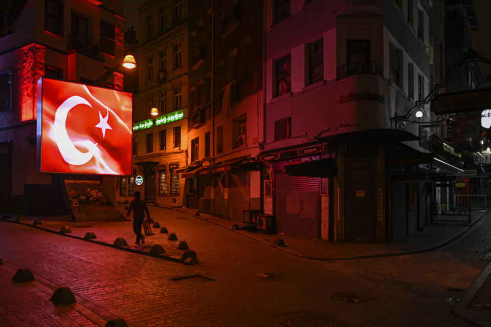 FILE - In this Wednesday, Nov. 25, 2020, file photo, a man walks during a night curfew, due to the virus pandemic, in Istanbul. When Turkey changed the way it reports daily COVID-19 infections, it confirmed what medical groups and opposition parties have long suspected — that the country is faced with an alarming surge of cases that is fast exhausting the Turkish health system. The official daily COVID-19 deaths have also steadily risen to record numbers in a reversal of fortune for the country that had been praised for managing to keep fatalities low. With the new data, the country jumped from being one of the least-affected countries in Europe to one of the worst-hit.(AP Photo, File)