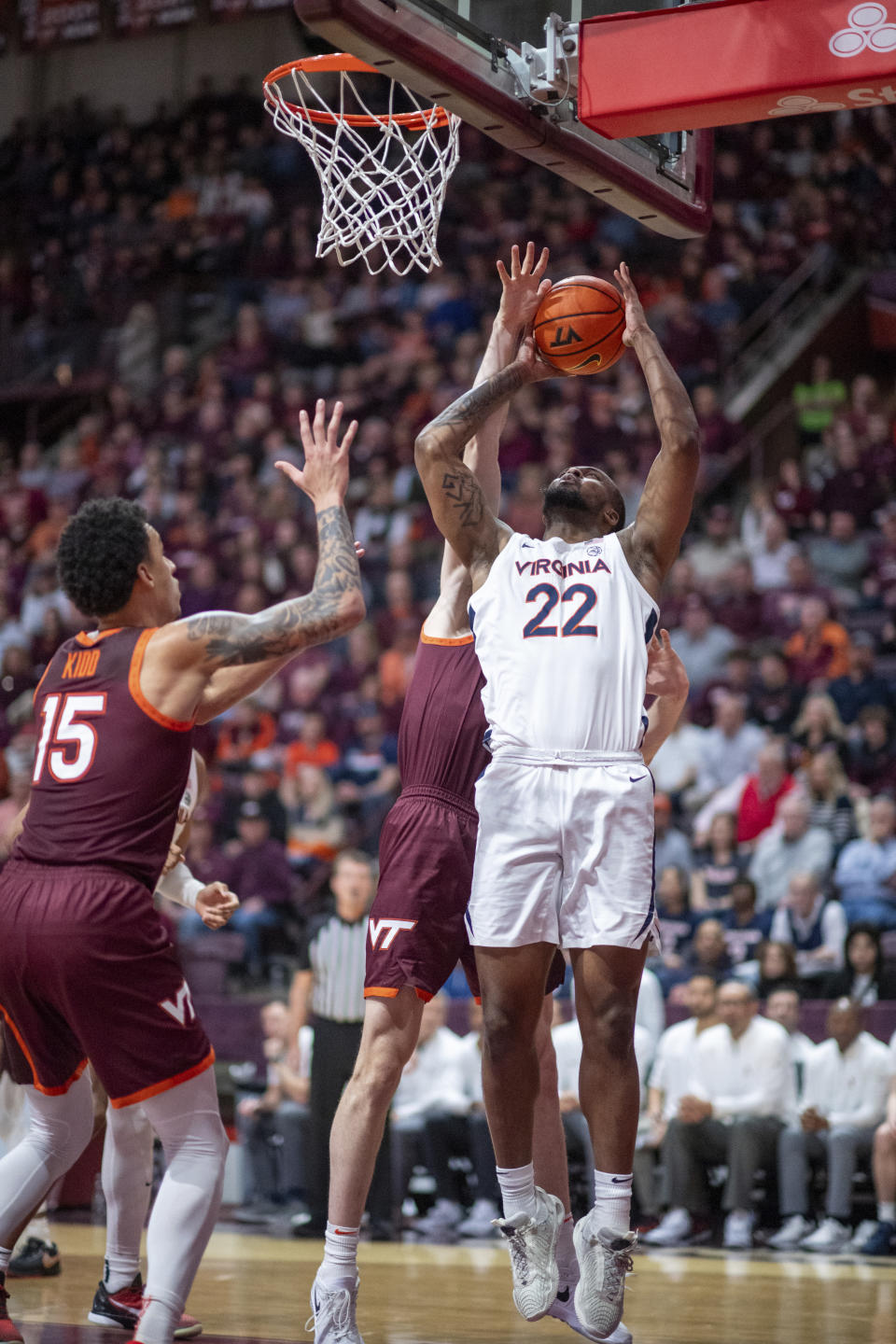 Virginia's Jordan Minor (22) is blocked by Virginia Tech's Robbie Beran and Lynn Kidd (15) during the second half of an NCAA college basketball game, Monday, Feb. 19, 2024, in Blacksburg, Va. (AP Photo/Robert Simmons)