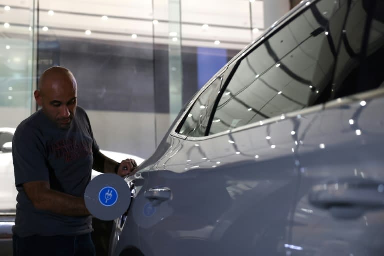 Un hombre inspecciona un coche eléctrico en una sala de exposición en Riad, el 8 de junio de 2024 (Fayez Nureldine)
