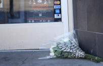 A bouquet of flowers is placed outside the door of a tattoo parlor along South Broadway Tuesday, Dec. 28, 2021 in Denver, one of the scenes of a shooting spree that left five people dead—including the suspected shooter Monday evening—and left three more people wounded. The spree spread from the core of Denver to the western suburb of Lakewood where the suspect was shot and killed by police near a busy intersection in a bustling shopping district. (AP Photo/David Zalubowski)