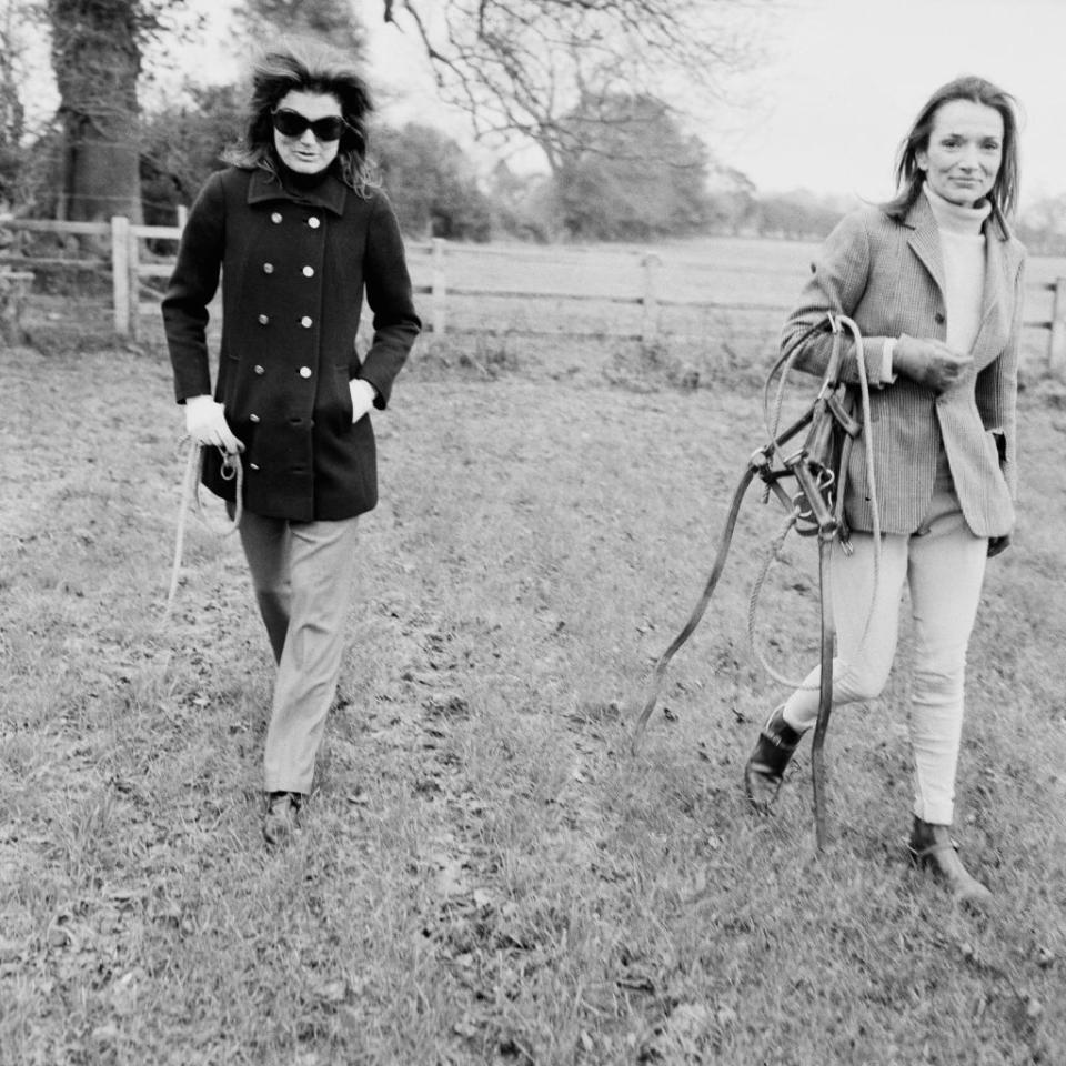 <p>Jackie and Lee Radziwill are photographed at a horse farm in the United Kingdom, appropriately dress in wool and tweed.<br></p>