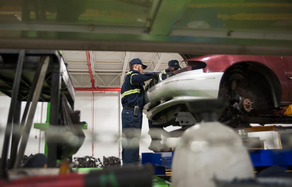 A worker disassembles a car at an EMR plant in South Camden in a September 2018 file photo.