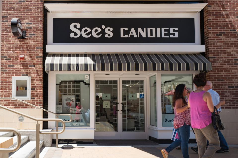 Shoppers walk past the facade of See's Candies in the upscale Broadway Plaza shopping center in Walnut Creek, California, July 30, 2017. See's Candies is division of Warren Buffett's Berkshire Hathaway conglomerate. (Photo by Smith Collection/Gado/Getty Images)