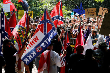 FILE PHOTO: Members of the Ku Klux Klan face counter-protesters as they rally in support of Confederate monuments in Charlottesville, Virginia, U.S. on July 8, 2017. REUTERS/Jonathan Ernst/File Photo