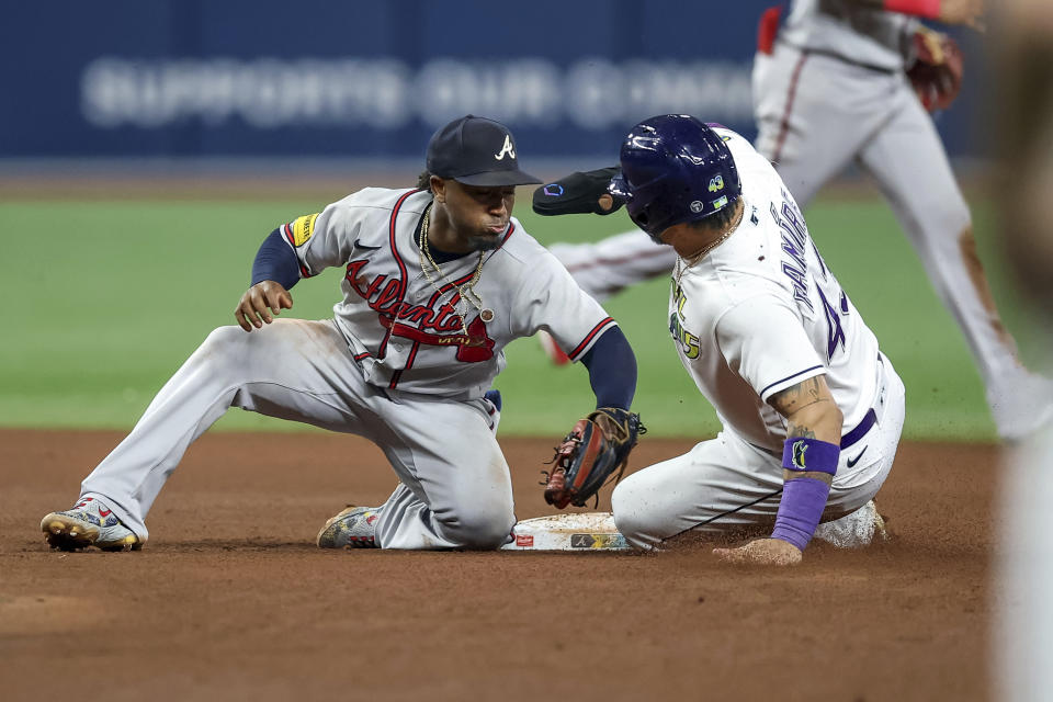 Atlanta Braves' Ozzie Albies tags out Tampa Bay Rays' Harold Ramirez on an attempted steal of second base during the seventh inning of a baseball game Friday, July 7, 2023, in St. Petersburg, Fla. (AP Photo/Mike Carlson)