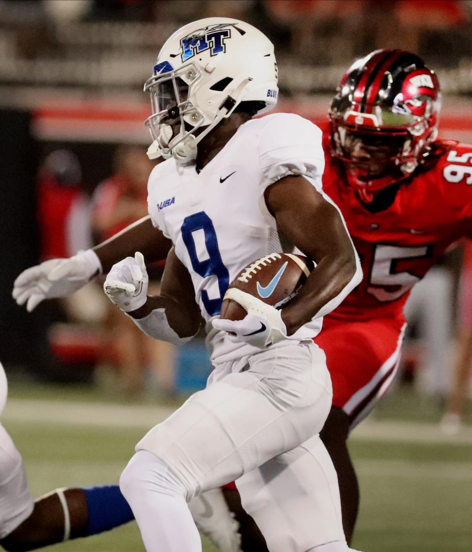 MTSU wide receiver Elijah Metcalf (9) runs the ball as Western Kentucky defensive end Deante McCray (95) comes up behind him during the football game at Houchens Industries L. T. Smith Stadium in Bowling Green Ky, on Thursday, Sept, 28, 2023.