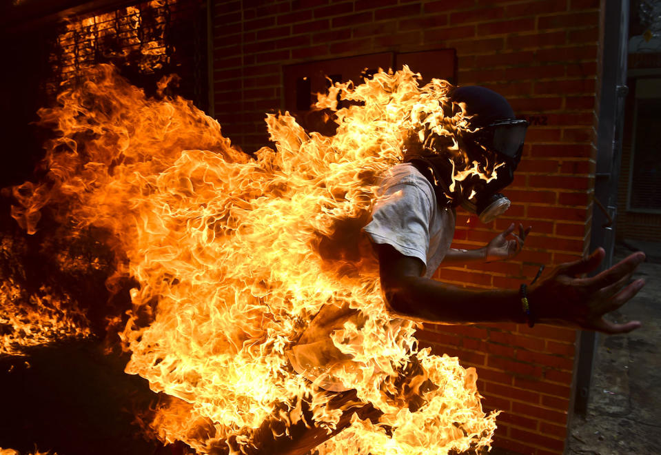 <p>An opposition activist suddenly turned into a human torch runs upon clashing with riot police during a protest against Venezuelan President Nicolas Maduro, in Caracas on May 3, 2017. (Photo credit should read RONALDO SCHEMIDT/AFP/Getty Images) </p>