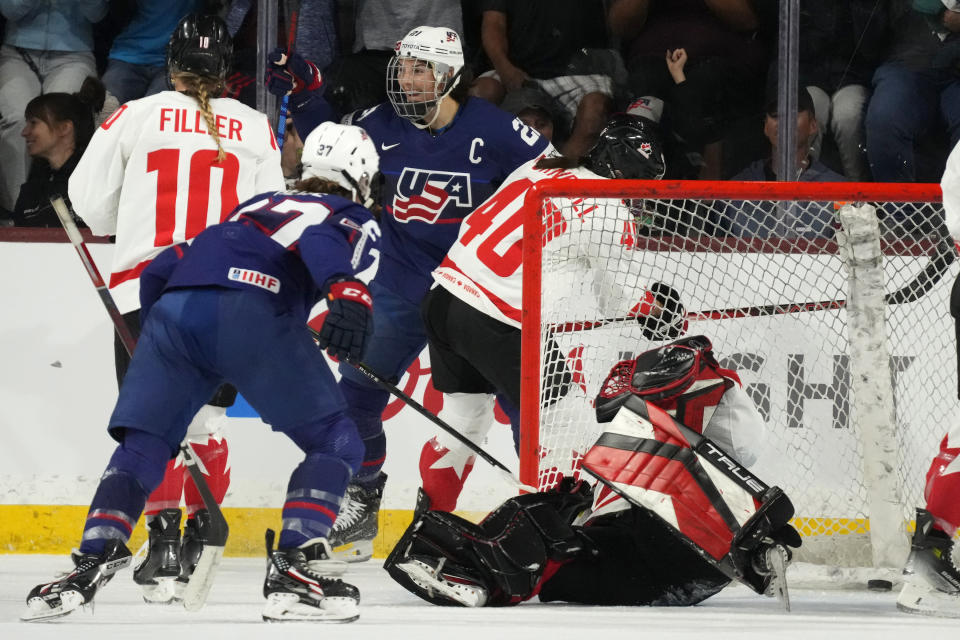 United States forward Hilary Knight, center, smiles as she celebrates her goal against Canada goaltender Emerance Maschmeyer, right, during the first period of a rivalry series women's hockey game Wednesday, Nov. 8, 2023, in Tempe, Ariz. (AP Photo/Ross D. Franklin)