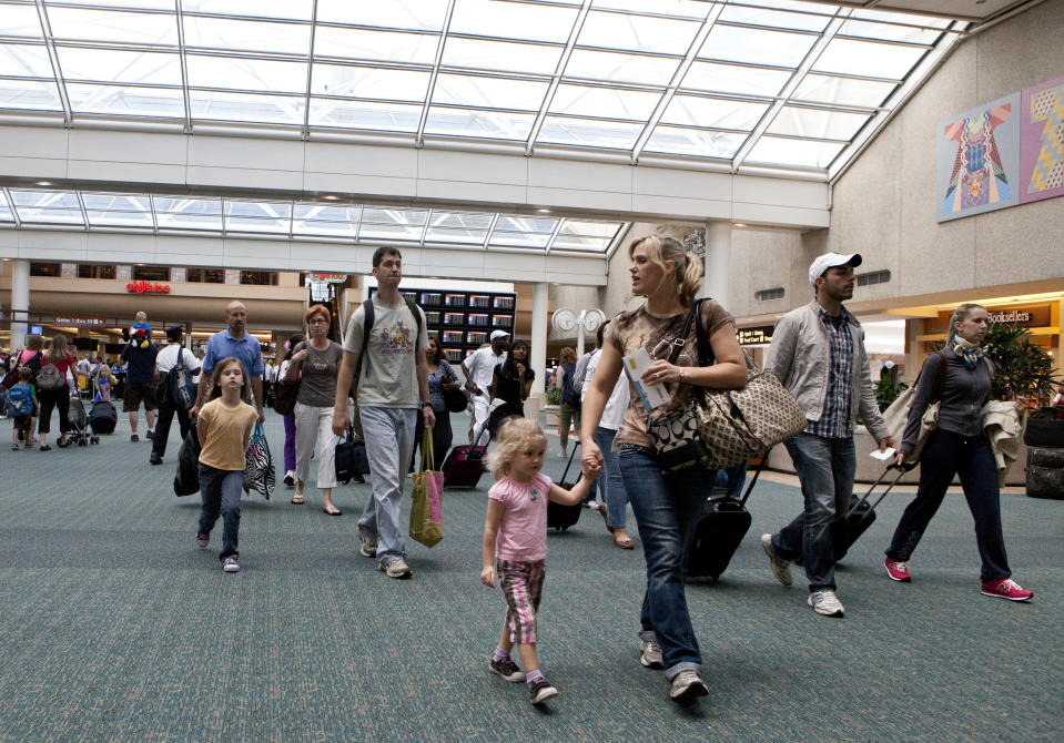FILE - In this Friday, May 25, 2012 file photo, travelers arrive at Orlando International Airport make their way to baggage claim in Orlando, Fla. Flying this summer doesn’t need to be expensive, as search engines, social media, creativity and flexibility can make finding bargain airfares easier. (AP Photo/John Raoux, File)