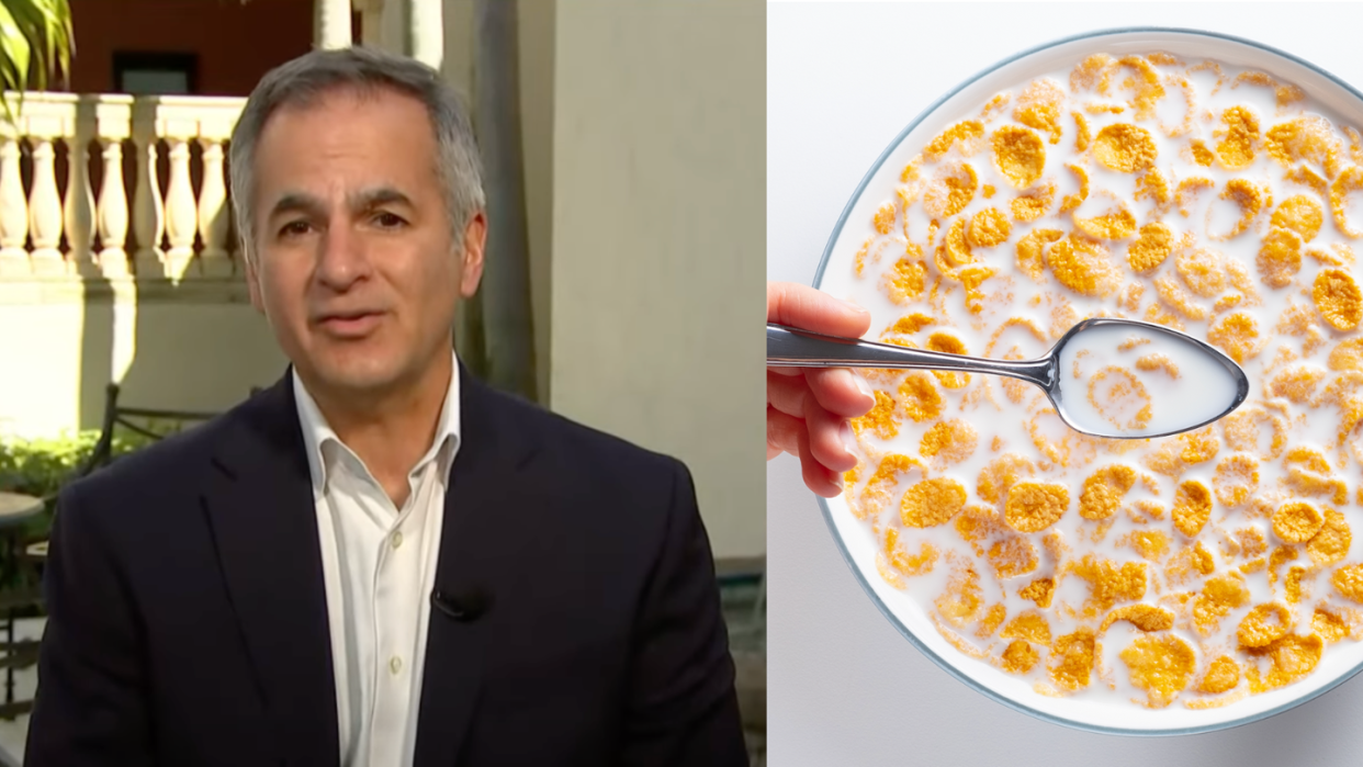 a man holding a spoon in front of a plate of food