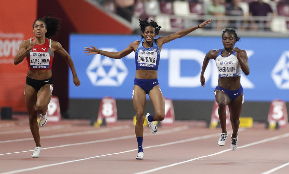 Mujinga Kambundji, of Switzerland, left, and Dina Asher-Smith, of Great Britain, race as English Gardner, of the United States pulls up injured in the women's 100 meter semifinal at the World Athletics Championships in Doha, Qatar, Sunday, Sept. 29, 2019. (AP Photo/Petr David Josek)