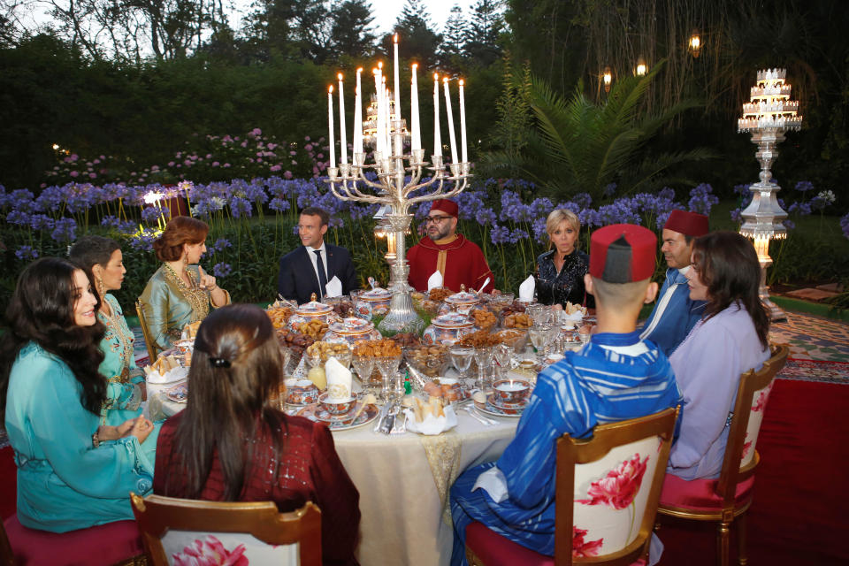 Morocco's King Mohammed VI (CR), his wife Princess Lalla Salma (background L), France's President Emmanuel Macron (CL) and his wife Brigitte Trogneux (background R), attend an Iftar meal, the evening meal when Muslims end their daily Ramadan fast at sunset, at the King Palace in Rabat, Morocco, June 14, 2017. Picture taken June 14, 2017.  REUTERS/Abdeljalil Bounhar/Pool