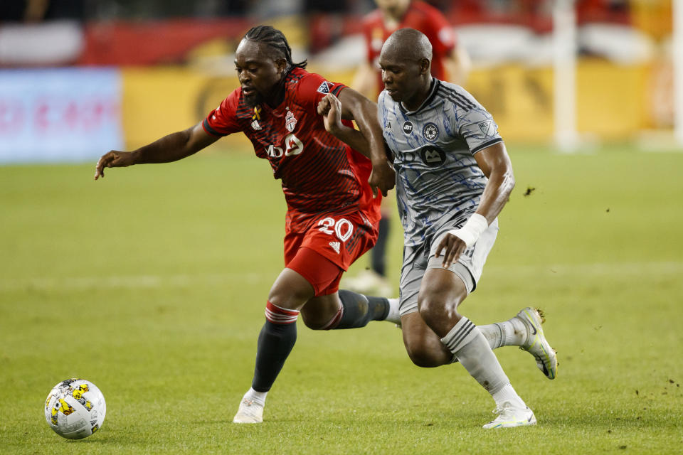 Toronto FC forward Ayo Akinola (20) and Montreal defender Rudy Camacho (4) run for the ball during first half MLS soccer action in Toronto on Sunday, Sept. 4, 2022. (Cole Burston/The Canadian Press via AP)