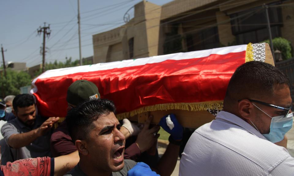 Mourners carry the flag-draped coffin of Hisham al-Hashimi during his funeral, in the Zeyouneh area of Baghdad, Iraq, Tuesday, July, 7, 2020. Al-Hashimi, an Iraqi analyst who was a leading expert on the Islamic State and other armed groups, was shot dead in Baghdad on Monday. (AP Photo/Khalid Mohammed)