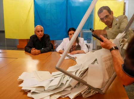 Members of a local electoral commission empty a ballot box at a polling station after a parliamentary election in Kiev