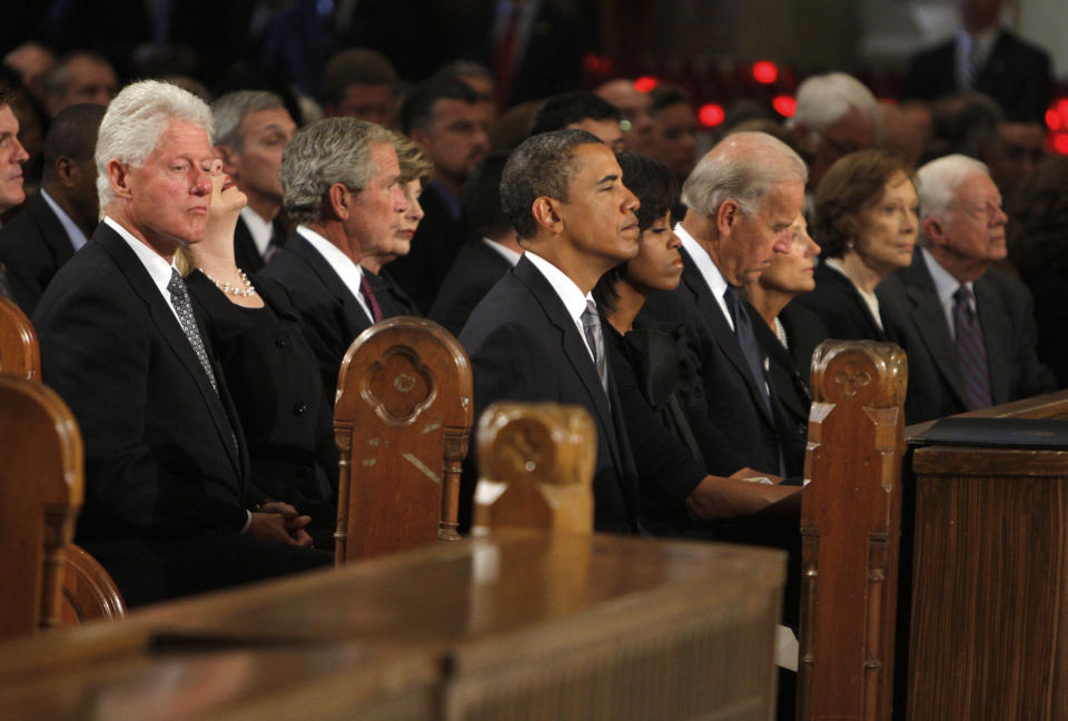 FILE - Former President Bill Clinton (L-R), Secretary of State Hillary Clinton, former president George W. Bush and his wife Laura, President Barack Obama and first lady Michelle Obama, Vice President Joseph Biden and his wife Jill, former first lady Rosalynn Carter and former President Jimmy Carter wait for the services to begin at during funeral services for U.S. Senator Edward Kennedy at the Basilica of Our Lady of Perpetual Help in Boston, Massachusetts August 29, 2009. AP Photo/Brian Snyder, Pool, File)