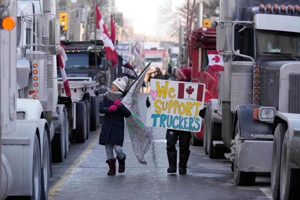 On Jan. 23, a convoy of trucks, dubbed Freedom Convoy 2022, rolled out from British Columbia and other parts of Canada en route to Ottawa to protest a vaccine mandate for cross-border truckers. Here, some protesters are seen walking near Parliament Hill in Ottawa on Saturday.