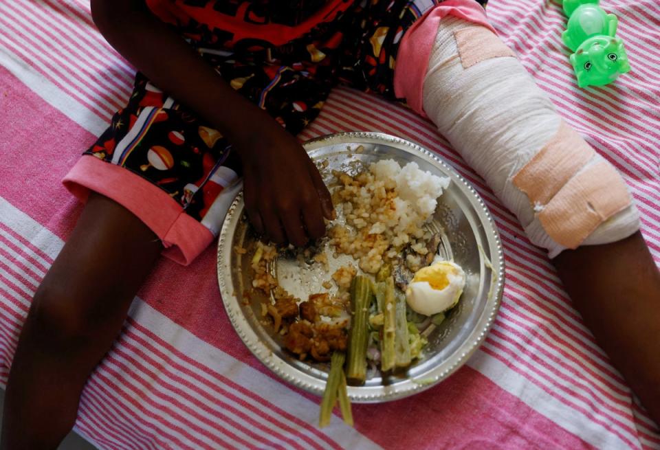 Enjoying some lunch on a bed at a cancer care transit home near Apeksha Hospital (Reuters)