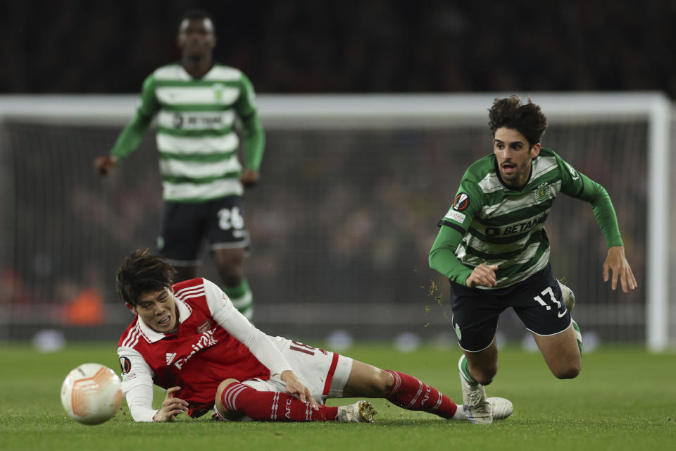 Arsenal's Takehiro Tomiyasu, left, duels for the ball with Sporting's Francisco Trincao during the Europa League round of 16, second leg, soccer match between Arsenal and Sporting CP at the Emirates stadium in London, Thursday, March 16, 2023. (AP Photo/Ian Walton)