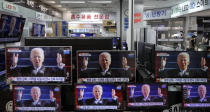A man stands near TV screens showing a news program reporting about U.S. President Joe Biden's inauguration, at an electronic shop in Seoul, South Korea, Thursday, Jan. 21, 2021. (AP Photo/Lee Jin-man)