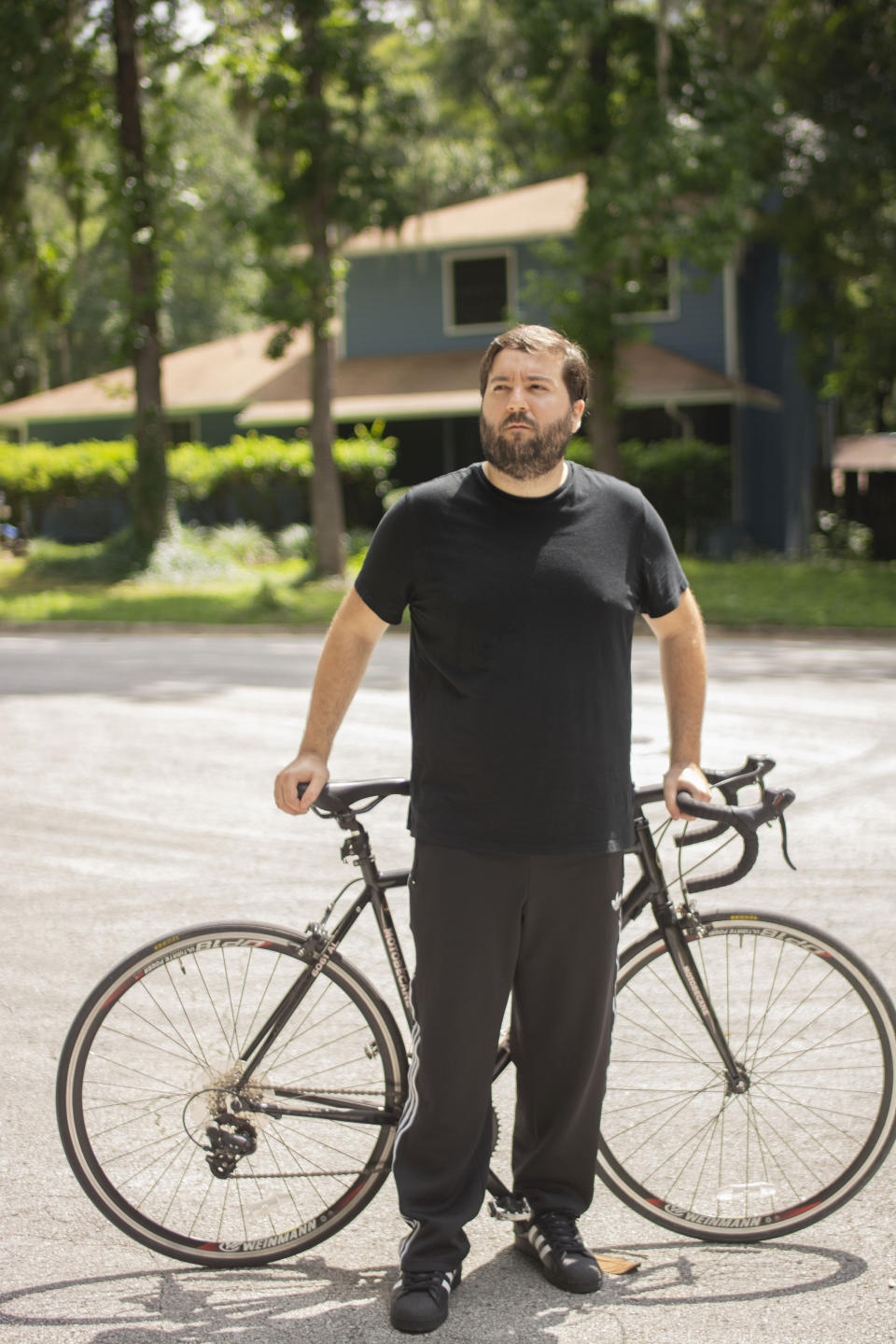 In this June 11, 2020, photo provided by Samuel Jones, his friend Zachary McCoy pauses on his bicycle in Gainesville, Fla. Local authorities considered McCoy a suspect in a house burglary because his Google location data showed he was near the house three times on the day the burglary occurred. McCoy said he rides his bike by the house regularly for exercise. Authorities were using geofence search warrants that allow law enforcement to gather data from Google on cellphone users and other devices near the scene of a crime. (Samuel Jones via AP)