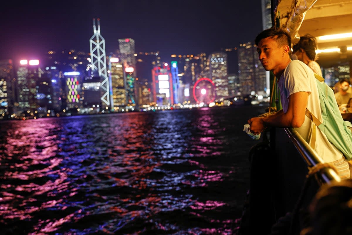 Craftsman Jesse Yu, 32, crosses on a ferry from  Victoria Harbour, with the financial district seen in the background, in Hong Kong (Reuters)