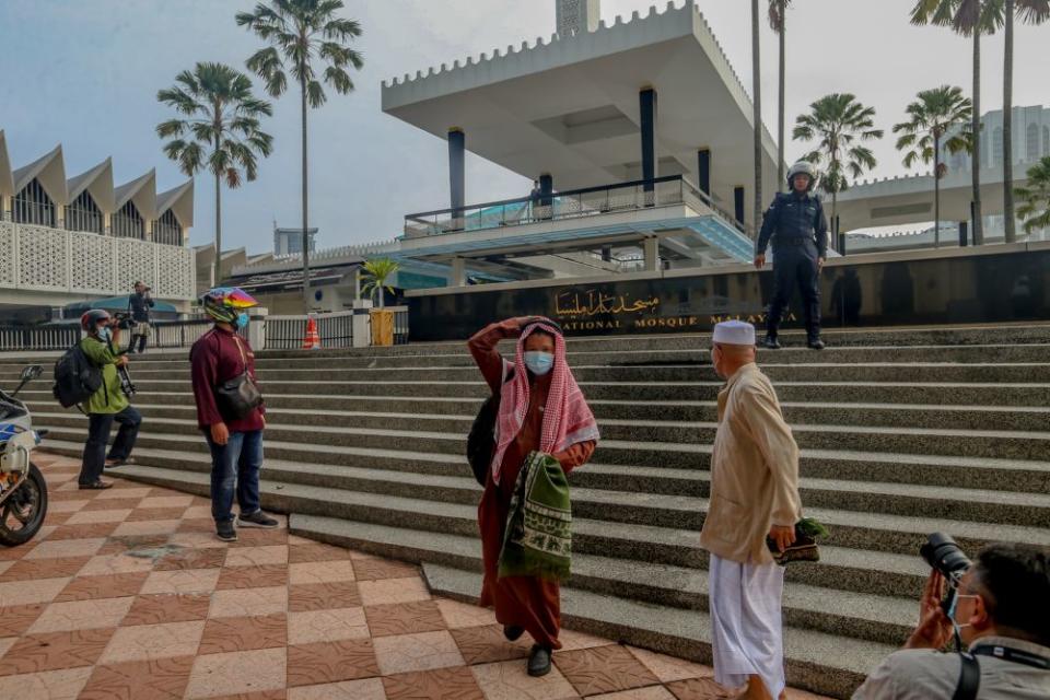 Police personnel instruct Muslims to leave the compound of the National Mosque, Kuala Lumpur May 24, 2020 — Picture by Firdaus Latif